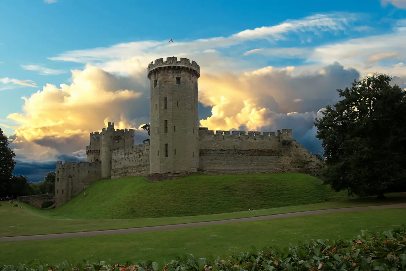 Warwick castle with thick clouds in the distance at sunset