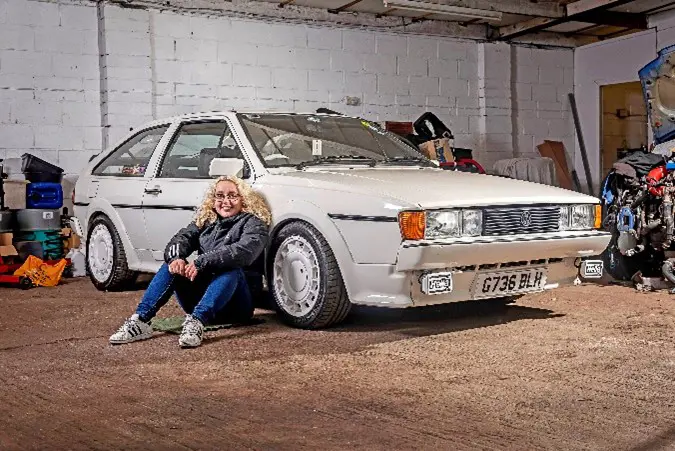 Woman sat near white car