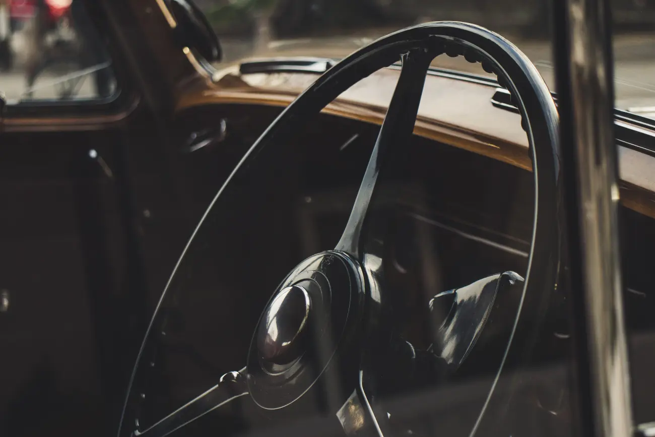 A person with two hands on their steering wheel