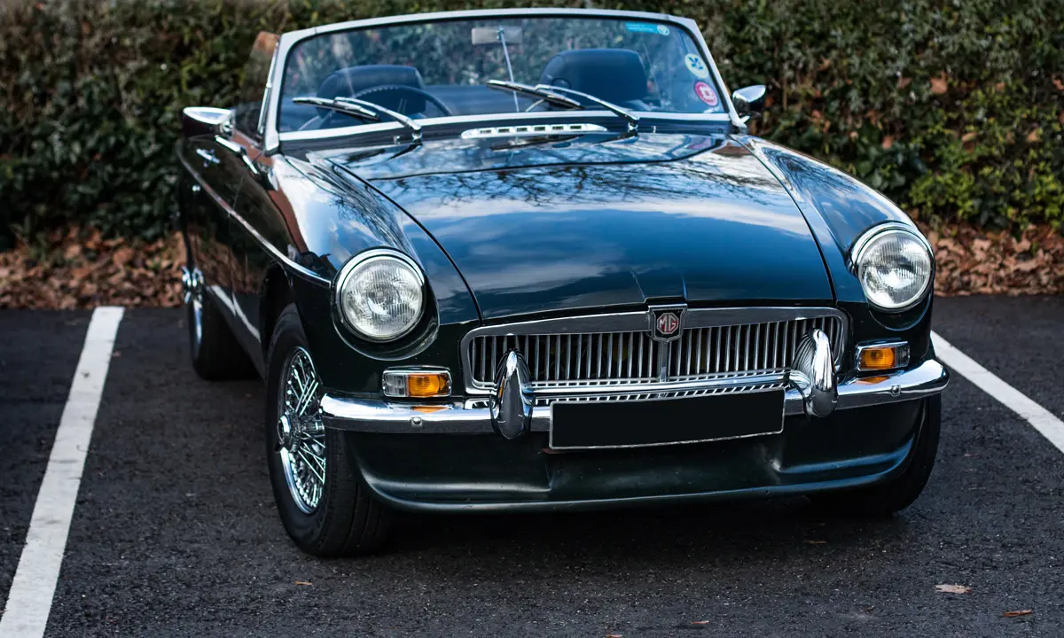 An MGB roadster with the roof down parked in a parking bay